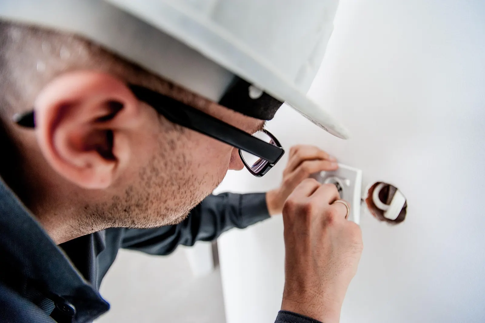 Elektriker med skyddshjälm monterar ett eluttag