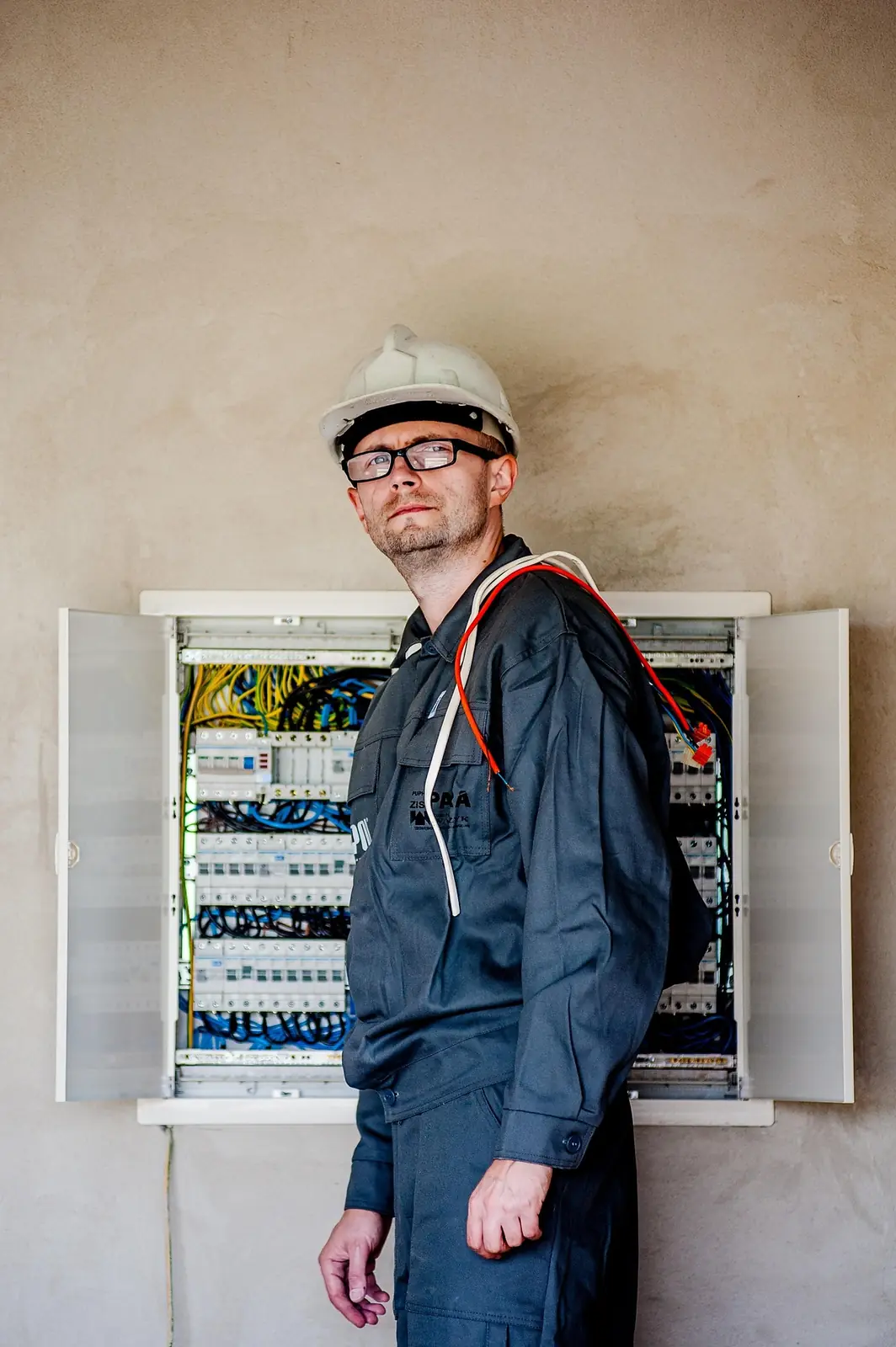 Elektriker framför en öppen elcentral